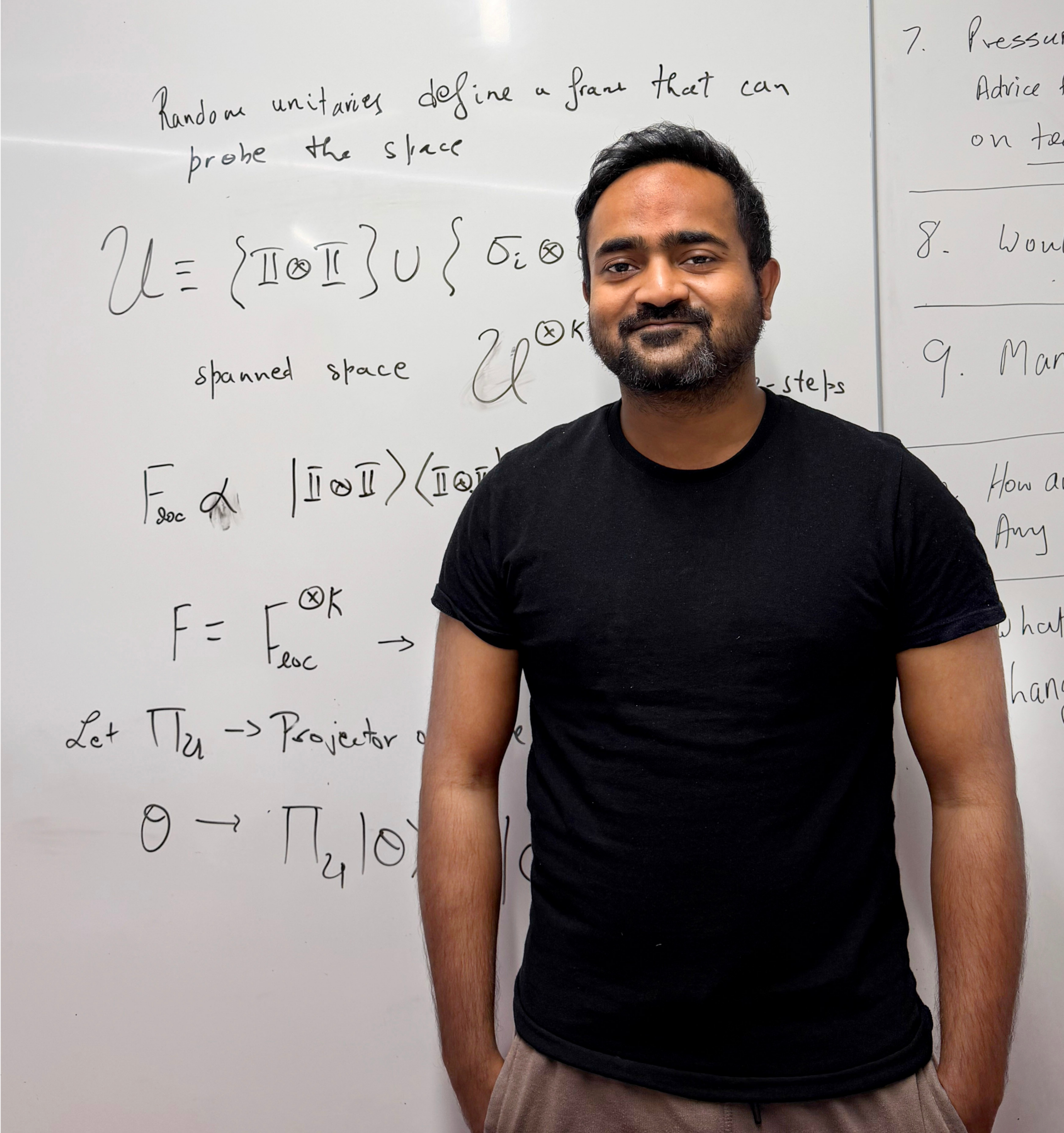 Varun Srivastava stands in front of a whiteboard with equations written on it